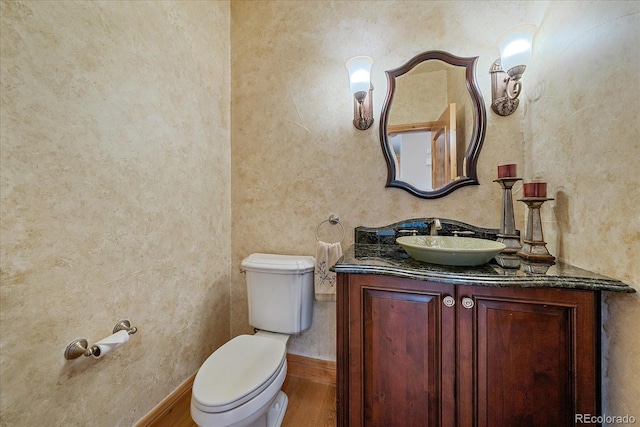 1015 Nob Hill Rd, Evergreen, CO 80439 - half bath featuring baseboards, wood finished floors, vanity, and toilet