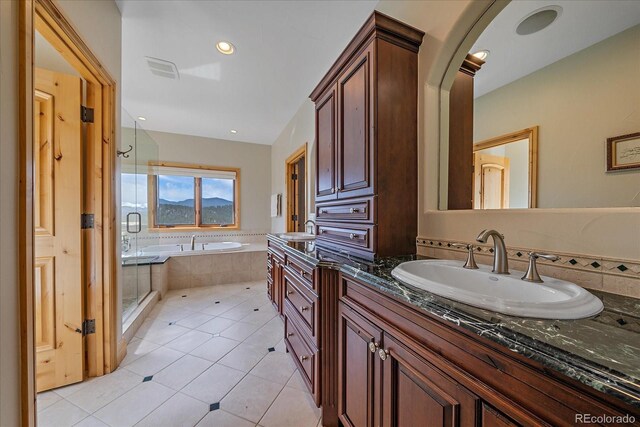 1015 Nob Hill Rd, Evergreen, CO 80439 - full bathroom with tile patterned floors, a stall shower, visible vents, a garden tub, and vanity