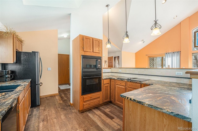 kitchen featuring black appliances, hanging light fixtures, dark stone countertops, dark hardwood / wood-style floors, and backsplash