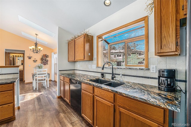 kitchen with vaulted ceiling, dishwasher, sink, backsplash, and hanging light fixtures