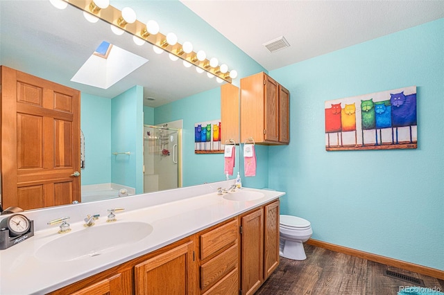 full bathroom with a skylight, vanity, wood-type flooring, plus walk in shower, and toilet