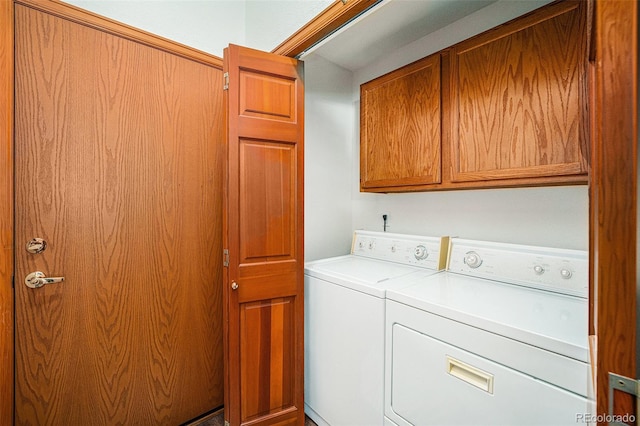 laundry room with separate washer and dryer and cabinets