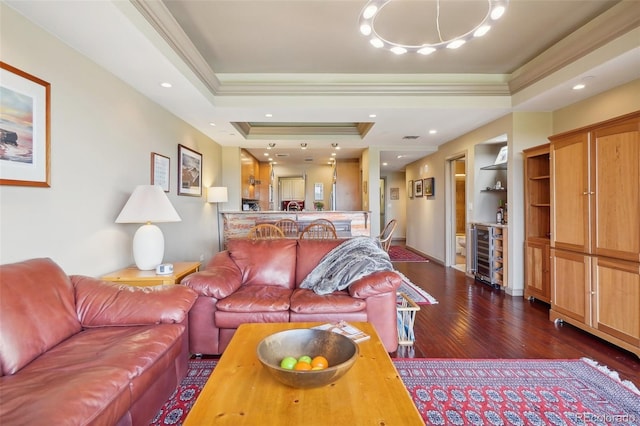 living room with crown molding, beverage cooler, a tray ceiling, and built in shelves