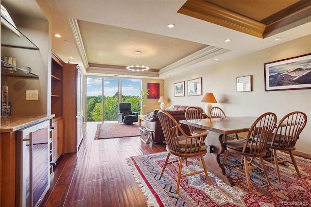 dining room featuring wine cooler, dark hardwood / wood-style floors, a raised ceiling, an inviting chandelier, and ornamental molding