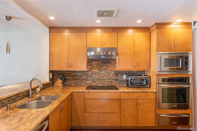 kitchen featuring range hood, a warming drawer, stainless steel appliances, visible vents, and a sink