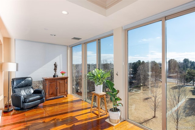 living area with floor to ceiling windows, recessed lighting, visible vents, and wood-type flooring