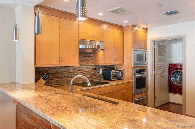 kitchen featuring a warming drawer, visible vents, under cabinet range hood, washer / clothes dryer, and appliances with stainless steel finishes