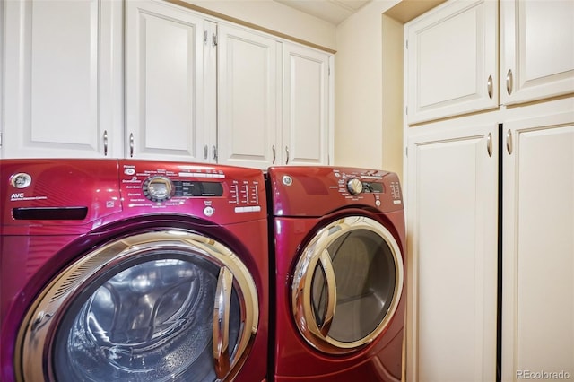 clothes washing area with cabinet space and washing machine and dryer