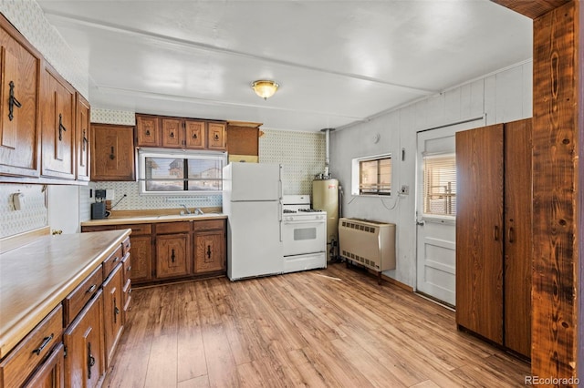 116 E 12th St, Leadville, CO 80461 - kitchen with light countertops, white appliances, light wood-style floors, brown cabinetry, and radiator heating unit