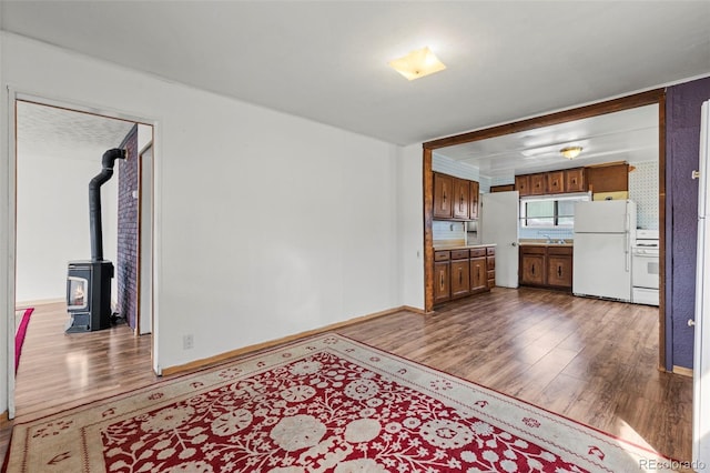 116 E 12th St, Leadville, CO 80461 - kitchen featuring brown cabinetry, freestanding refrigerator, stove, and dark wood-style flooring