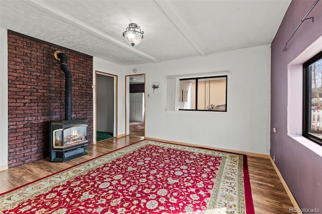 116 E 12th St, Leadville, CO 80461 - interior space with a wood stove, baseboards, beam ceiling, and wood finished floors