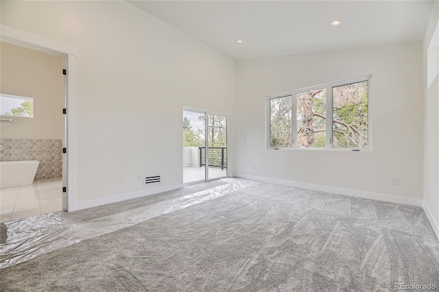 carpeted empty room featuring plenty of natural light and vaulted ceiling