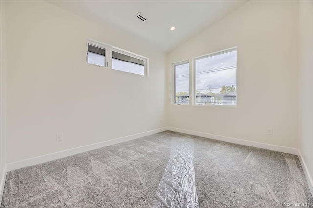 empty room featuring carpet floors and vaulted ceiling