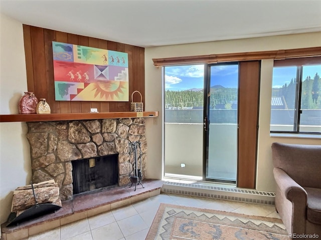 tiled living room featuring a mountain view and a stone fireplace