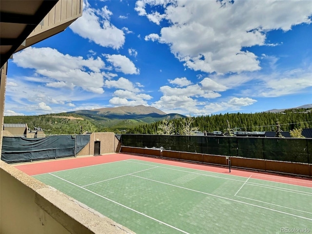 view of sport court featuring a mountain view and basketball hoop