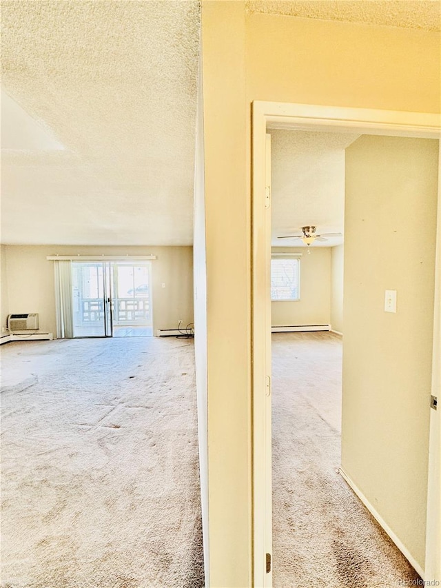 hall with a wealth of natural light, a textured ceiling, and carpet floors