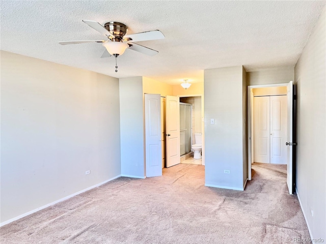 unfurnished bedroom with baseboards, light colored carpet, and a textured ceiling