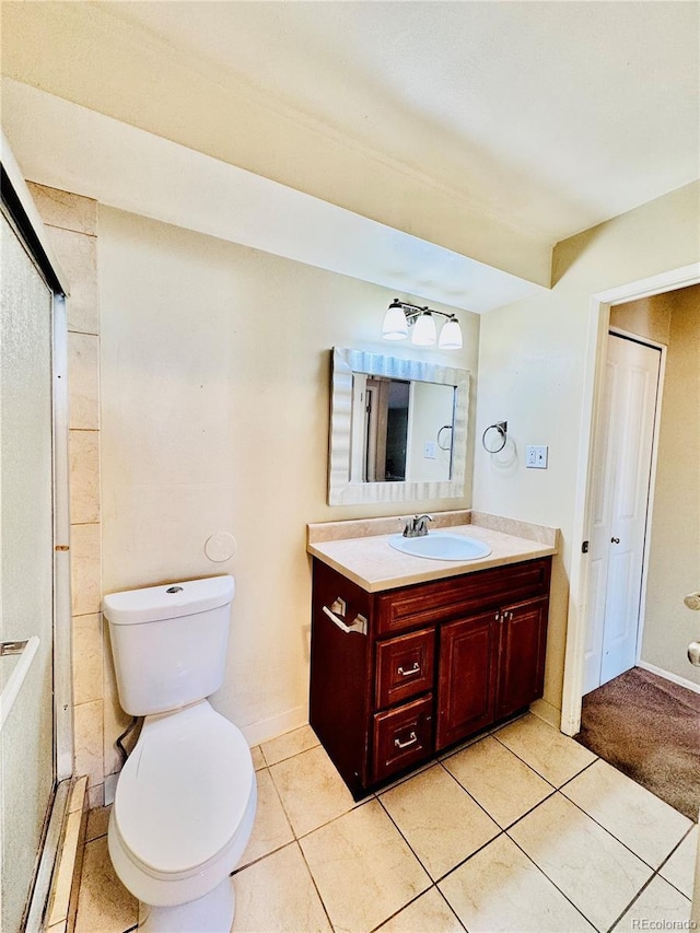 bathroom with vanity, tile patterned floors, toilet, and a shower with shower door