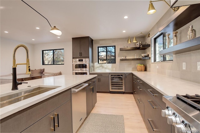 kitchen with dishwasher, decorative backsplash, light wood-type flooring, wine cooler, and sink