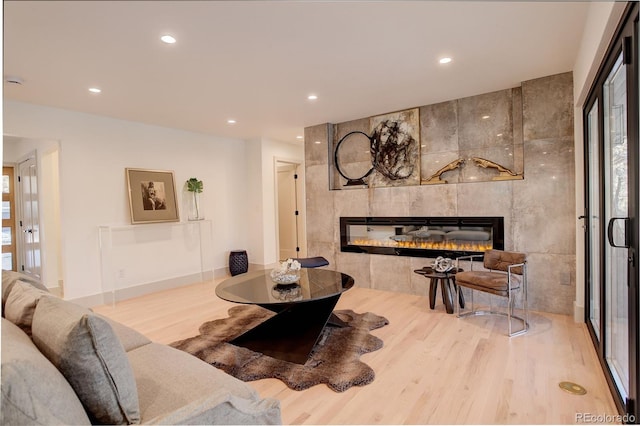 living room featuring a tile fireplace and light hardwood / wood-style floors