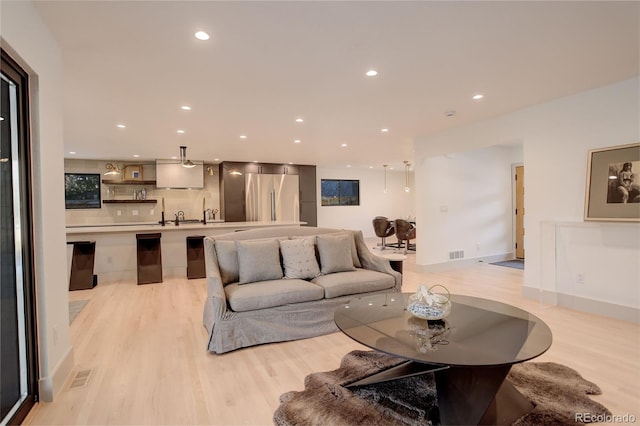 living room with sink and light hardwood / wood-style floors