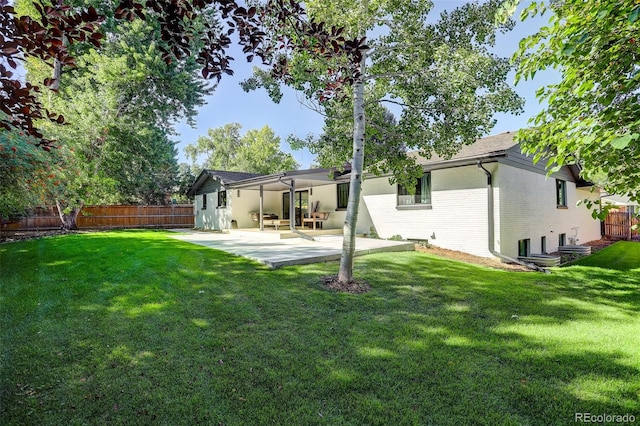 rear view of property featuring a yard and a patio