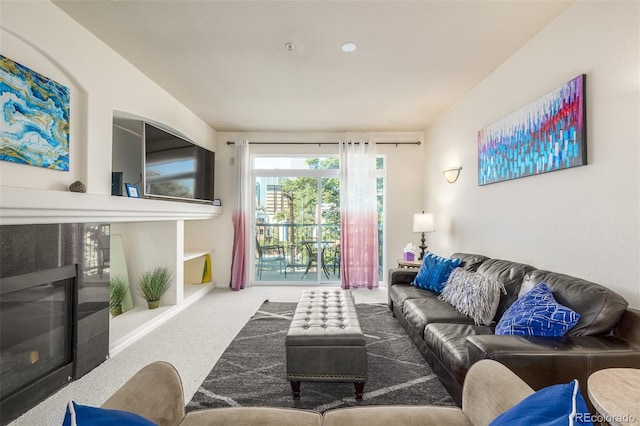 living area featuring carpet flooring and a glass covered fireplace