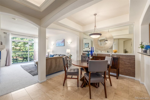 dining space with light carpet, light tile patterned floors, baseboards, arched walkways, and a raised ceiling