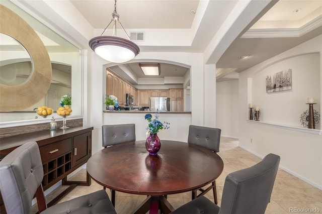 dining room with light tile patterned floors, a raised ceiling, visible vents, and baseboards