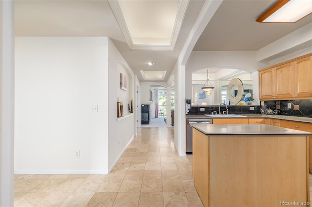 kitchen with a kitchen island, a sink, backsplash, dishwasher, and a raised ceiling