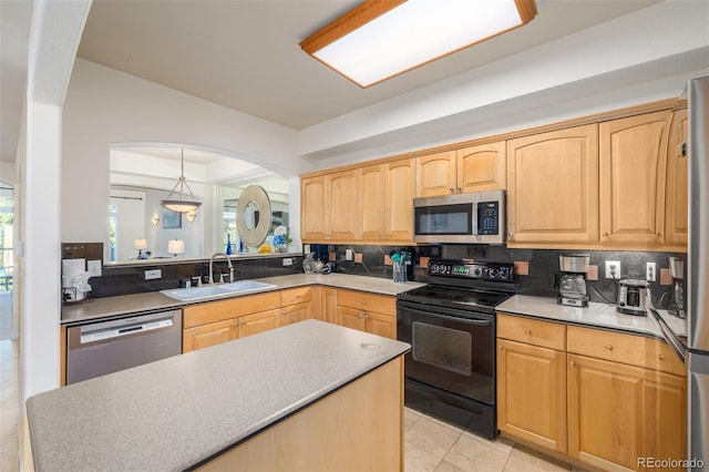 kitchen featuring light brown cabinets, stainless steel appliances, a sink, and decorative backsplash