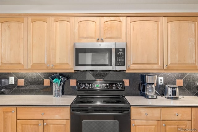 kitchen with electric range, decorative backsplash, stainless steel microwave, light countertops, and light brown cabinets