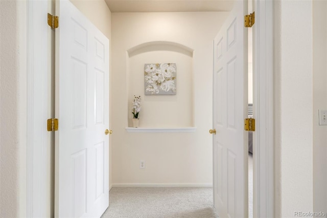 hallway with carpet flooring and baseboards