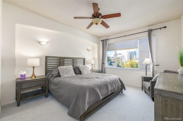 bedroom featuring light carpet, baseboards, and a ceiling fan