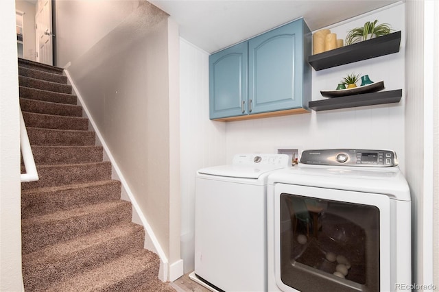 washroom with washer and dryer and cabinets