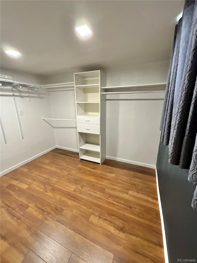 walk in closet with hardwood / wood-style flooring