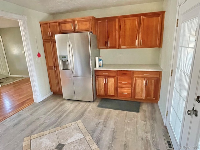 kitchen featuring light wood-type flooring and stainless steel refrigerator with ice dispenser