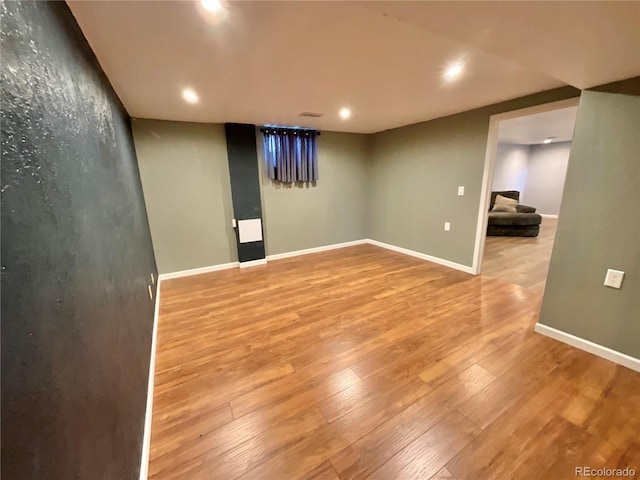 basement with hardwood / wood-style flooring