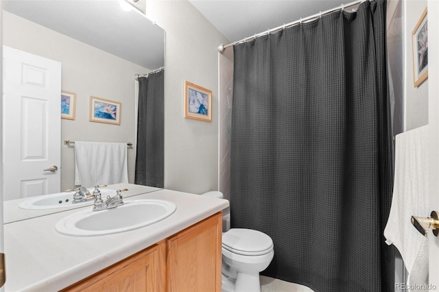 bathroom with curtained shower, vanity, and toilet