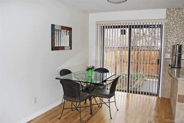 dining space featuring wood finished floors and baseboards