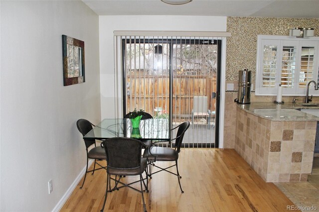 dining space featuring light wood-type flooring and baseboards
