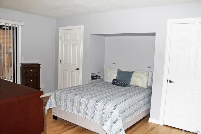 bedroom with baseboards and wood finished floors