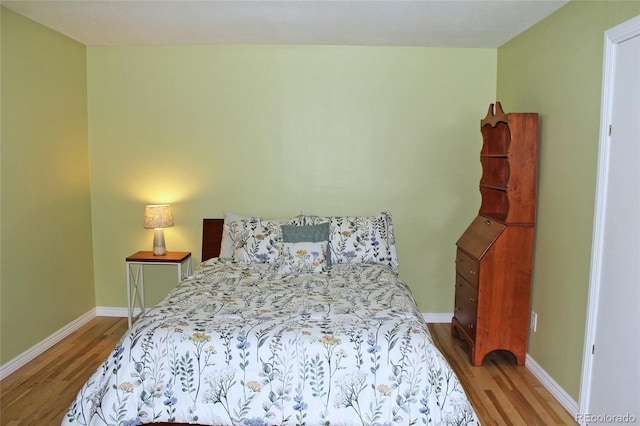 bedroom featuring baseboards and wood finished floors