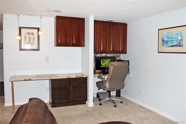office area featuring visible vents, light carpet, baseboards, and built in study area