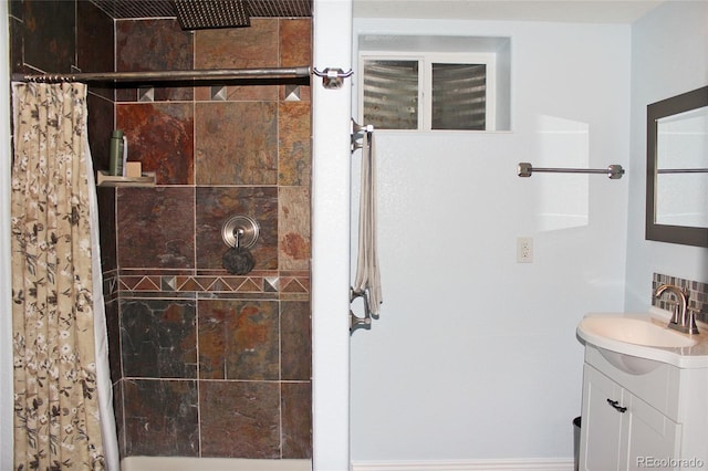 full bathroom with a tile shower and vanity