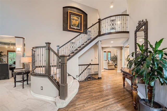 9445 Aspen Hill Cir, Lone Tree, CO 80124 - entrance foyer featuring a high ceiling, plenty of natural light, arched walkways, wood finished floors, and stairway