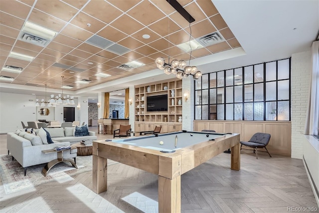 playroom featuring billiards, a drop ceiling, built in shelves, a raised ceiling, and light parquet flooring