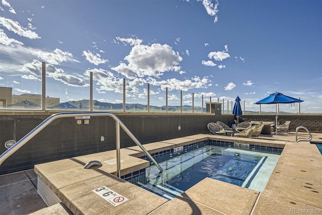 view of swimming pool featuring a mountain view, a hot tub, and a patio