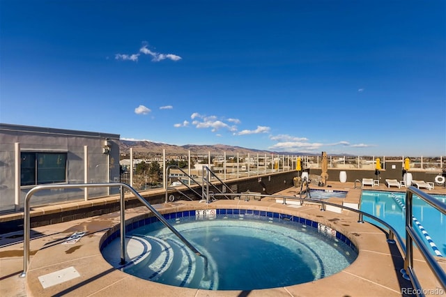 view of pool featuring a hot tub and a mountain view