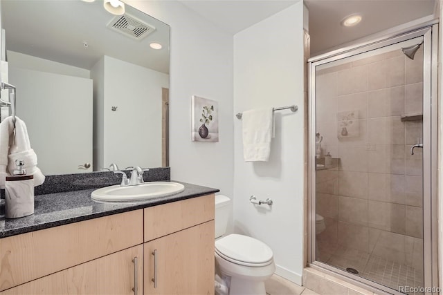 bathroom featuring vanity, toilet, tile patterned flooring, and a shower with door